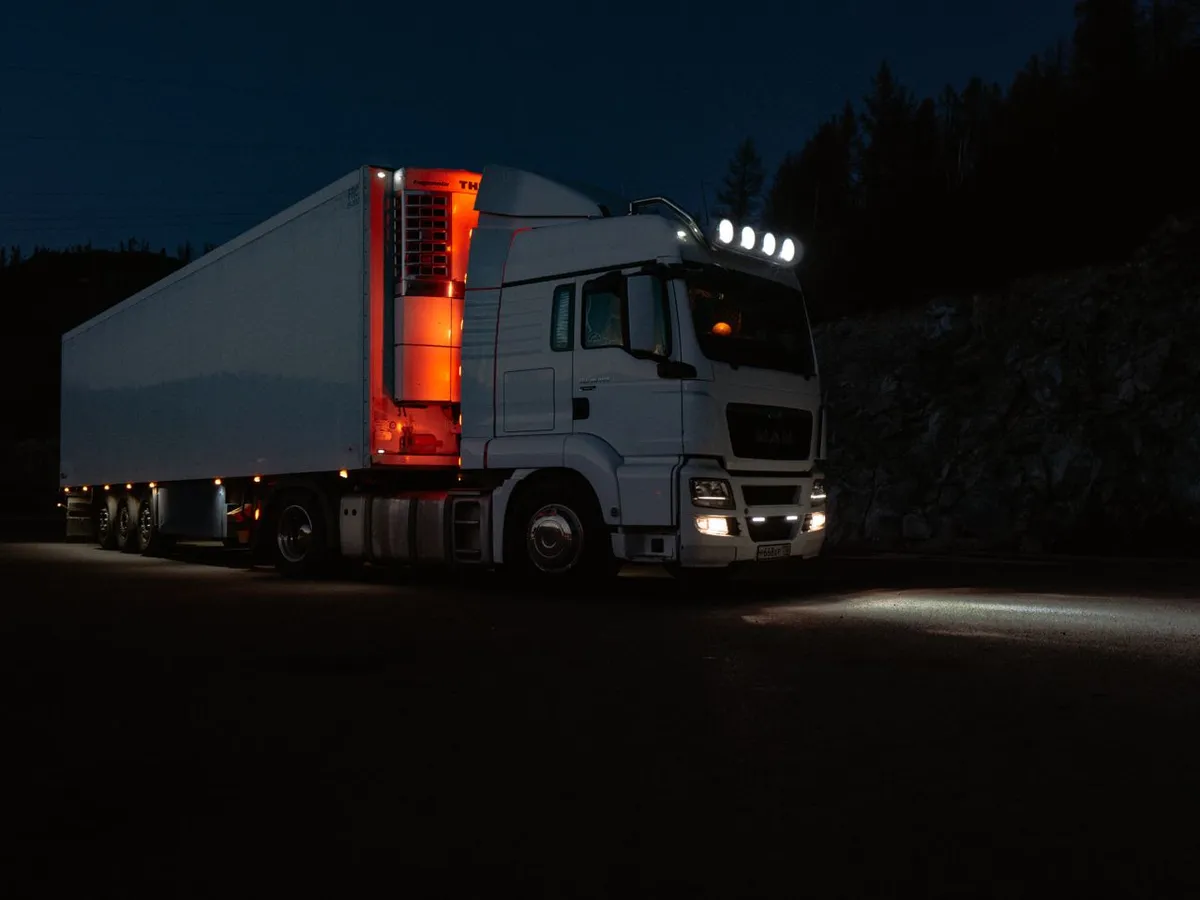 Semi-trailer truck at night showing LED marker lights, headlights and side lighting system